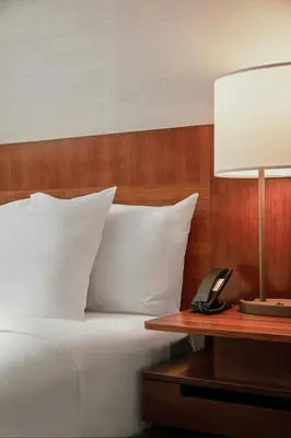 a bed with a lamp and a phone on a table at Fairfield Inn & Suites Columbus OSU in Columbus