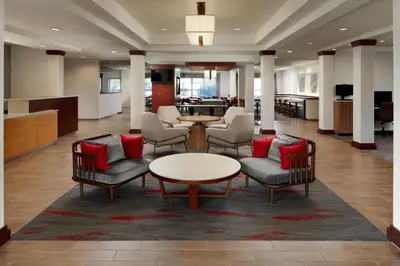 a lobby with chairs and a table with red pillows at Fairfield Inn & Suites Columbus OSU in Columbus