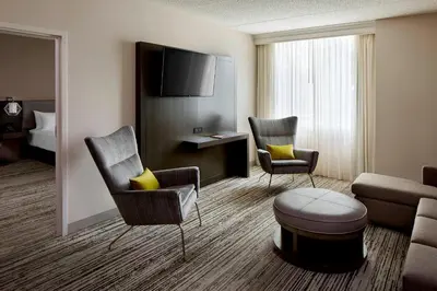 a hotel room with a bed and a living room at Marriott Cincinnati Airport in Hebron