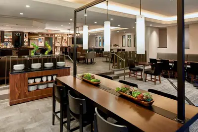 a restaurant with tables and chairs and a bar at Marriott Cincinnati Airport in Hebron
