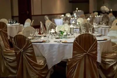 a set of tables with white table cloths and chairs at Marriott Cincinnati Airport in Hebron