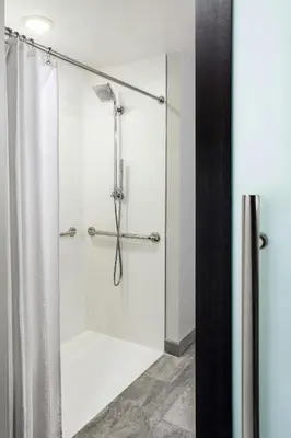 a bathroom with a shower with a glass door at Marriott Cincinnati Airport in Hebron