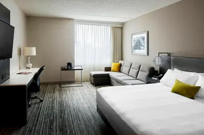 a hotel room with a bed and a couch at Marriott Cincinnati Airport in Hebron