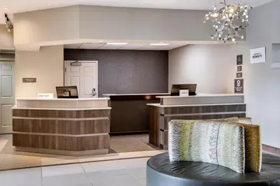 a hotel lobby with a waiting area and a counter at Residence Inn Cincinnati Airport in Erlanger