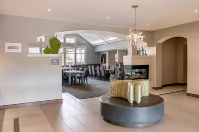 a living room with a fireplace and a dining room at Residence Inn Cincinnati Airport in Erlanger