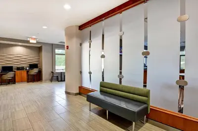 a waiting room at a hospital with a green couch at SpringHill Suites by Marriott Cincinnati Midtown in Cincinnati