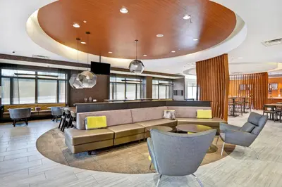 a lobby with a couch and a table and chairs at SpringHill Suites by Marriott Cincinnati Midtown in Cincinnati