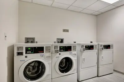 a laundry room with three washing machines in it at SpringHill Suites by Marriott Cincinnati Midtown in Cincinnati