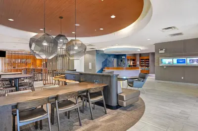 a restaurant with tables and chairs and a bar at SpringHill Suites by Marriott Cincinnati Midtown in Cincinnati