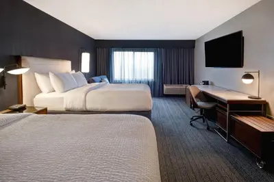 a hotel room with two beds and a desk at Courtyard by Marriott Cincinnati Airport in Erlanger