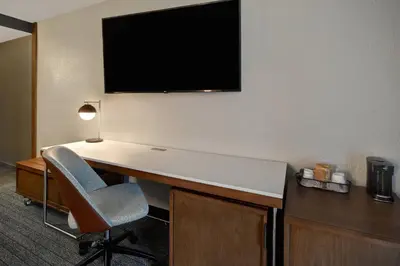 a room with a desk with a tv and a chair at Courtyard by Marriott Cincinnati Airport in Erlanger