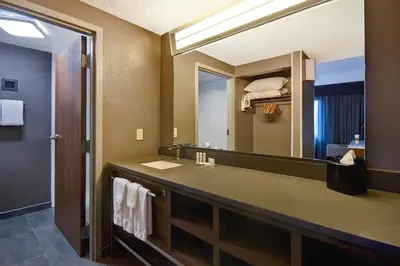 a bathroom with a sink and a large mirror at Courtyard by Marriott Cincinnati Airport in Erlanger