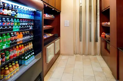a refrigerator filled with lots of bottles of soda at Courtyard Hamilton in Hamilton