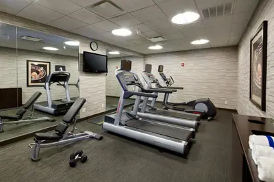 a gym with several cardio machines in a room at Courtyard Hamilton in Hamilton