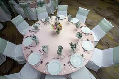 a pink table with white plates and silverware on it at Courtyard Hamilton in Hamilton