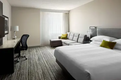 a hotel room with a large bed and a couch at Marriott Cincinnati Northeast in Mason