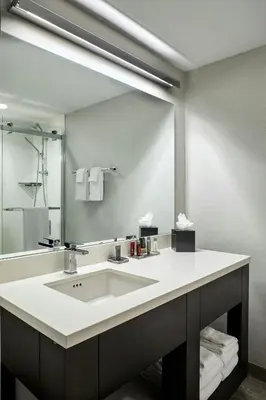 a bathroom with a sink and a large mirror at Marriott Cincinnati Northeast in Mason