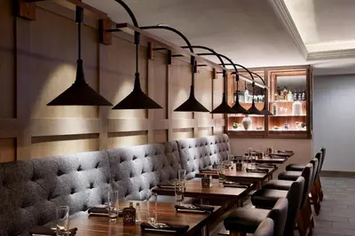 a restaurant with wooden tables and chairs and lights at Marriott Cincinnati Northeast in Mason