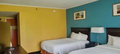 a hotel room with two beds and blue and yellow walls at Chester Inn & Suites in Sharonville