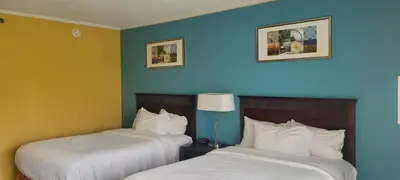 two beds in a hotel room with blue walls at Chester Inn & Suites in Sharonville