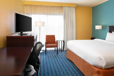 a hotel room with a bed and a flat screen tv at Chester Inn & Suites in Sharonville