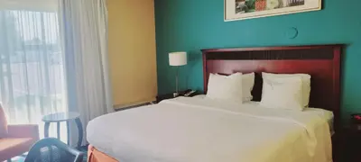 a bedroom with a large bed and a blue wall at Chester Inn & Suites in Sharonville