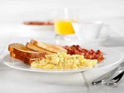 a plate of breakfast food with eggs bacon and toast at Courtyard by Marriott Springfield Downtown in Springfield