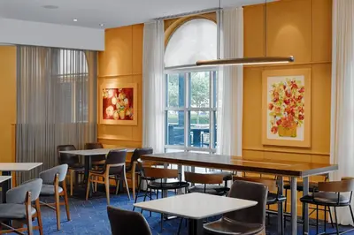 a dining room with tables and chairs and a window at Courtyard by Marriott Springfield Downtown in Springfield