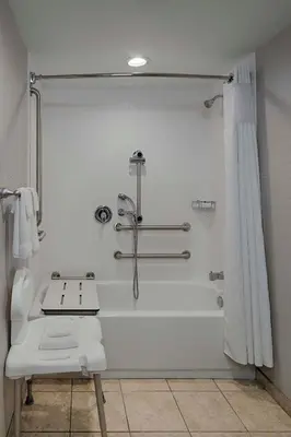 a white bathroom with a shower and a sink at Courtyard by Marriott Springfield Downtown in Springfield