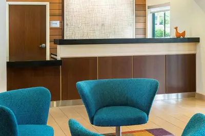 a waiting area with blue chairs in a waiting room at Fairfield Inn & Suites Springfield in Springfield