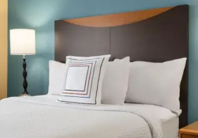 a bedroom with a bed with white pillows at Fairfield Inn & Suites Springfield in Springfield