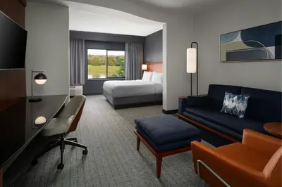 a hotel room with a couch and a bed at Courtyard Dayton-University of Dayton in Dayton