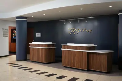 a lobby with two counters and a blue wall at Courtyard Dayton-University of Dayton in Dayton