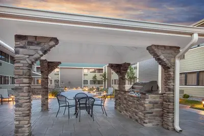 a patio with a grill and tables and chairs at Wyndham Garden Fort Wayne in Fort Wayne