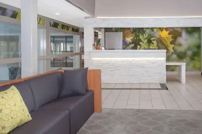 a living room with a couch and a fireplace at Wyndham Garden Fort Wayne in Fort Wayne