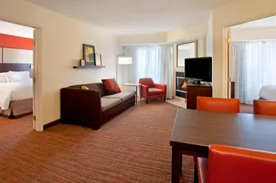 a hotel room with a couch and a bed at Residence Inn by Marriott Fort Wayne Southwest in Fort Wayne