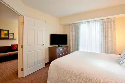 a bedroom with a bed and a flat screen tv at Residence Inn by Marriott Fort Wayne Southwest in Fort Wayne