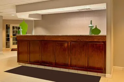a lobby with a bar with green vases on it at Residence Inn by Marriott Fort Wayne Southwest in Fort Wayne