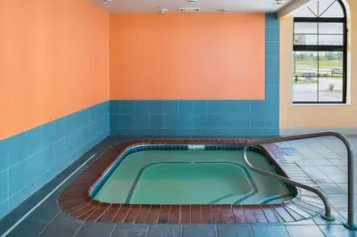 a hot tub in a room with blue and orange walls at Motel 6-Richmond, IN in Richmond
