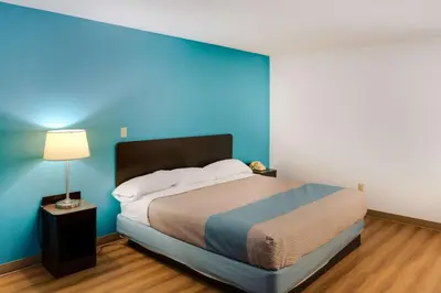 a bedroom with a bed with a blue wall at Motel 6-Richmond, IN in Richmond
