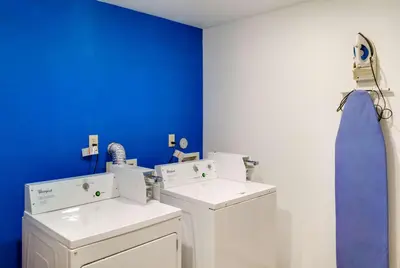 a bathroom with two washing machines and a blue wall at Motel 6-Richmond, IN in Richmond