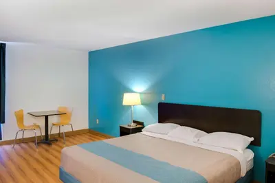 a bedroom with a large bed and a blue wall at Motel 6-Richmond, IN in Richmond