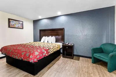 a hotel room with a bed and a chair at Econo Lodge Akron Copley Northwest in Montrose