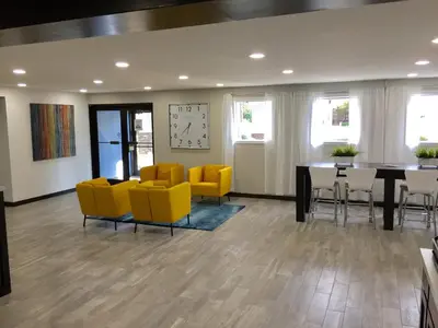 a dining room with yellow chairs and a table at Days Inn & Suites by Wyndham Cincinnati North in Springdale