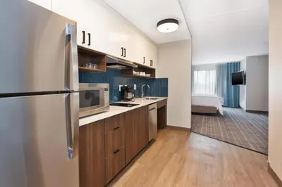 a kitchen with a refrigerator and wooden cabinets at Staybridge Suites Pittsburgh Airport by IHG in Pittsburgh