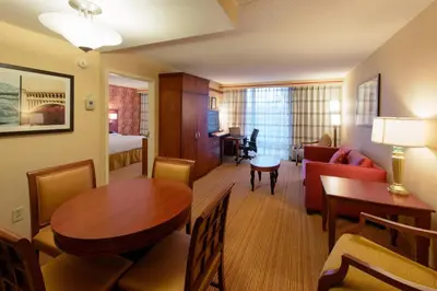 a hotel room with a dining table and a living room at Courtyard by Marriott Canton in North Canton
