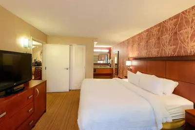 a bedroom with a bed and a flat screen tv at Courtyard by Marriott Canton in North Canton