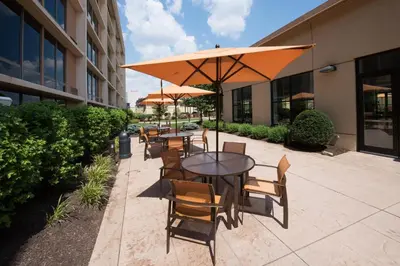 a patio with tables and chairs with an umbrella at Courtyard by Marriott Canton in North Canton