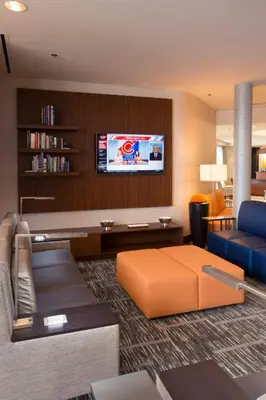 a living room with a couch and a tv at Courtyard by Marriott Canton in North Canton