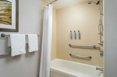 a bathroom with a white tub and a shower at Courtyard by Marriott Akron Stow in Stow